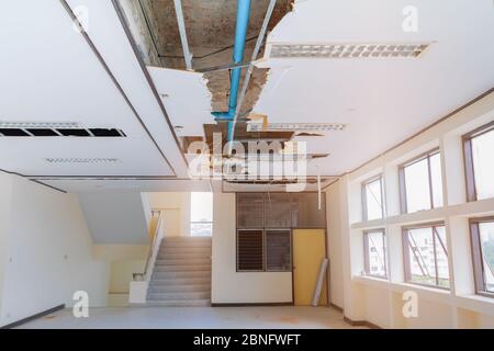 riparare il tubo di scarico dell'acqua sull'edificio degli uffici interni del soffitto in gesso Foto Stock