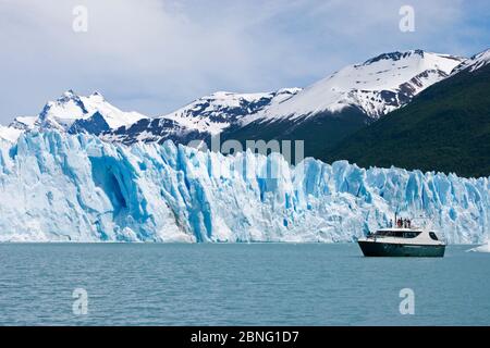 I turisti che osservano il ghiacciaio Perito Moreno da vicino dalla barca del tour in Canal de los Tempanos (canale di Iceberg), Lago Argentino, Parco Nazionale Los Glaciares Foto Stock