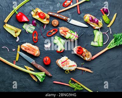 Gustosa bruschetta italiana con verdure e ingredienti sul tavolo da cucina Foto Stock