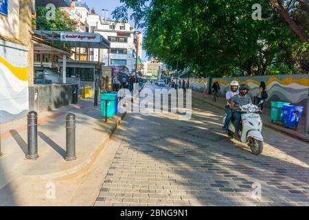 Persone in sella a uno scooter nella famosa Church Street di Bangalore Foto Stock