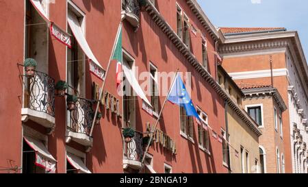 Bandiera italiana e dell'Unione europea su un edificio decorativo a Venezia Foto Stock