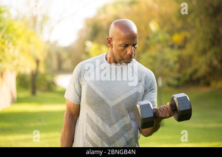 Montare African American uomo sollevamento pesi al di fuori. Foto Stock