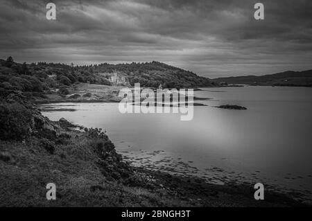 Panorama bianco e nero della baia di Dunvegan Loch con il castello di Dunvegan Foto Stock
