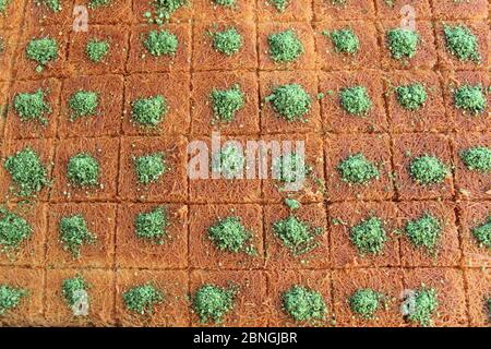 Tradizionale dessert turco Kadayif cotto allo sciroppo servito con pistacchi in polvere. Kadayif dolce turco con pistacchio. Foto Stock