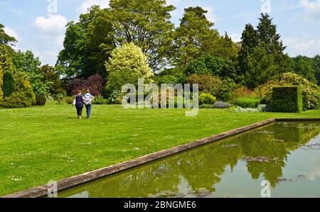 Coppia a piedi da un lago in Waterperry Gardens, Waterperry, vicino Wheatley, Oxfordshire, Regno Unito Foto Stock