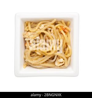 Cucina Asiatica - Stir noodle fritte in una ciotola quadrata isolata su sfondo bianco Foto Stock