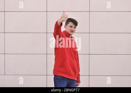 ritratto di un ragazzo sorridente. vestirsi in una camicia rossa Foto Stock