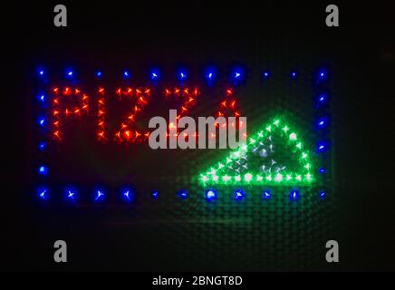 Retro segno neon di pizza su sfondo nero Foto Stock