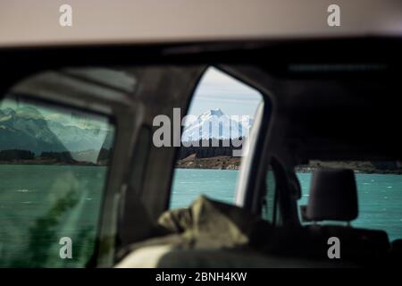 Vista di un lago e la cima della bella montagna innevata catturata dall'interno di un veicolo Foto Stock