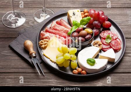 Formaggi, carni, uva e olive antipasto. Piatto di selezione degli antipasti Foto Stock