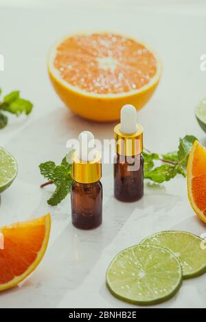 Organici cosmetici con estratti di erbe di limone, arancio, menta su sfondo lucido Foto Stock