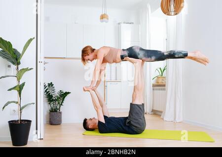 Fratelli adulti che fanno ginnastica insieme durante l'isolamento a casa Foto Stock