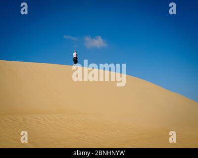 Siwa, Egitto, una donna sta camminando sulla cima delle dune di sabbia del deserto Foto Stock