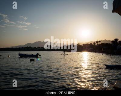 Una tavola da paddle stand up è uno dei modi migliori per godersi il tramonto a Dahab egitto Foto Stock