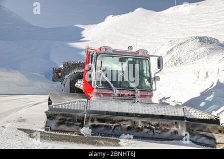 Primo piano della macchina a cremagliera sulla strada alpina in Austria, sulle montagne alpine primaverili innevate. Foto Stock