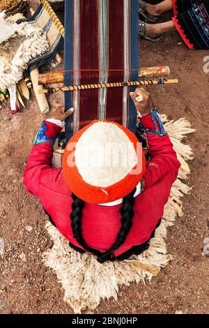 Donna seduta al telaio della cinghia posteriore. Progetto di tessitura femminile sostenuto da Planeterra, Huchuy Qosco, villaggio indigeno, Valle Sacra, Perù. Dicembre 2013. Foto Stock