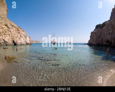 MILOS, GRECIA - 14 LUGLIO 2017: Piccola spiaggia Tsigrado con persone che nuotano in acque cristalline dell'isola di Milos, Grecia Foto Stock