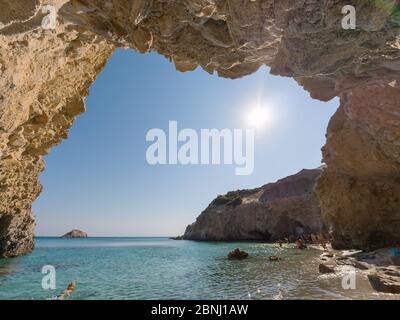 Piccola grotta sulla spiaggia di Tsigrado con acque cristalline dell'isola di Milos, Grecia Foto Stock