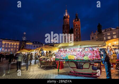 Mercatini di Natale di notte con la Basilica di Santa Maria, Piazza del mercato, Patrimonio dell'Umanità dell'UNESCO, Cracovia, Polonia, Europa Foto Stock