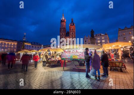 Bancarelle di Natale di notte con la Basilica di Santa Maria, Piazza del mercato, Patrimonio dell'Umanità dell'UNESCO, Cracovia, Polonia, Europa Foto Stock