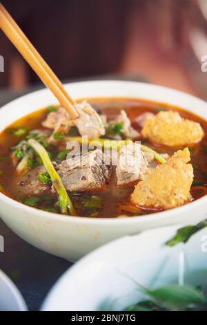 Un piatto fumante di Bun Bo Hue, il brodo di manzo locale piccante o hotpot, in un ristorante locale, Hue, Vietnam, Indocina, Sud-Est Asiatico, Asia Foto Stock