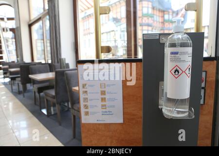 Wernigerode, Germania. 15 maggio 2020. Il disinfettante è appeso agli ospiti e ai visitatori del caffè all'ingresso. La caffetteria sulla piazza del mercato è in fase di preparazione per l'apertura. A tal fine, i tavoli saranno disposti secondo la normativa sulla distanza e saranno adottate misure di igiene speciali. I ristoranti e le caffetterie della Sassonia-Anhalt possono riaprire a partire dal 18.05.2020 in base a norme rigorose. Credit: Matrhias Bein/dpa-Zentralbild/dpa/Alamy Live News Foto Stock