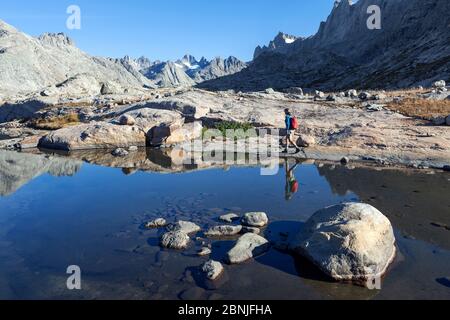 Donna escursionista a piedi intorno lago di montagna in Titcomb Basin in Wind River Range di Bridger Wilderness, Bridger National Forest, Wyoming, Stati Uniti. 2 settembre Foto Stock