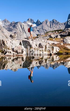 Escursionista esplorando il lago di montagna nel bacino di Titcomb, Wind River Range, Bridger Wilderness, Bridger National Forest, Wyoming, Stati Uniti. Settembre 2015. Modalità Foto Stock