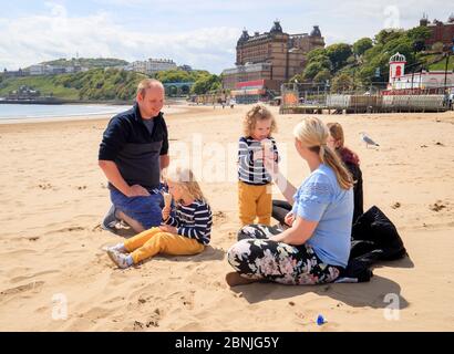 Una famiglia goda i gelati sulla spiaggia di Scarborough nello Yorkshire, dopo l'introduzione delle misure per portare il paese fuori dal blocco. Foto Stock