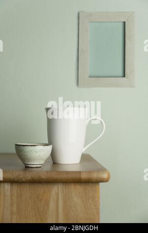 tazza di ceramica bianca e tazza da tè su tavola in legno naturale con cemento blu vintage e parete grigia cornice per cibo bevanda e sfondo casa Foto Stock