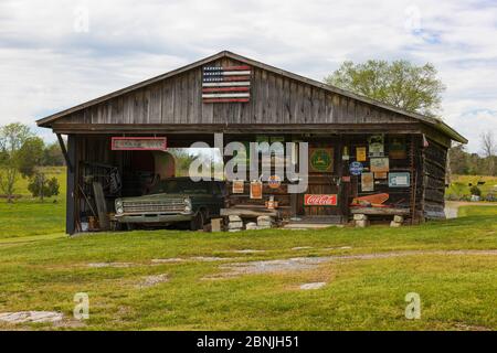 Tazewell, Tennessee, USA - 28 aprile 2020: Visto da una strada di campagna una vecchia struttura in legno con vecchi cartelli pubblicitari e una vecchia auto. Foto Stock