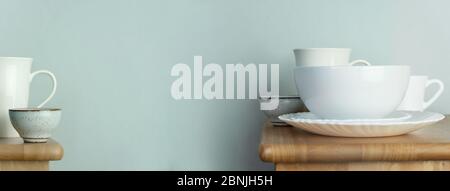 tazza di caffè e tè in ceramica bianca o tazza e piatto per cibo e bevande su tavolo di legno con sfondo banner web vintage blu interno Foto Stock