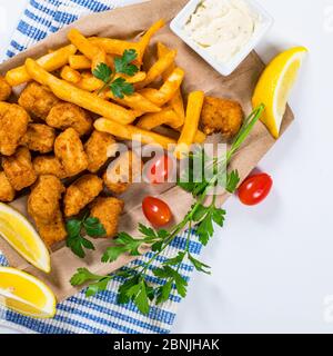 Croccante Pesce morsi snack dimensione. Barrette di pesce Pollock fritte con salsa tartara Foto Stock