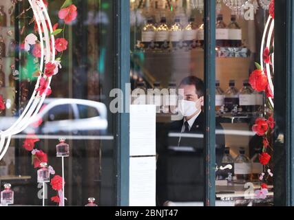 Parigi, Francia. 15 maggio 2020. Un uomo di sicurezza che indossa la maschera è visto in un negozio presso gli Champs Elysees Avenue a Parigi, Francia, 15 maggio 2020. Il primo ministro francese Edouard Philippe ha annunciato giovedì un pacchetto di misure per un totale di 18 miliardi di euro (circa 19.44 miliardi di dollari) per salvare il settore turistico che è stato duramente colpito dalla pandemia del coronavirus. Credit: Gao Jing/Xinhua/Alamy Live News Foto Stock