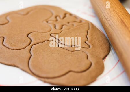 Natale gioia di tagliare i biscotti da pasta di pan di zenzero, con una varietà di taglierine decorative Foto Stock