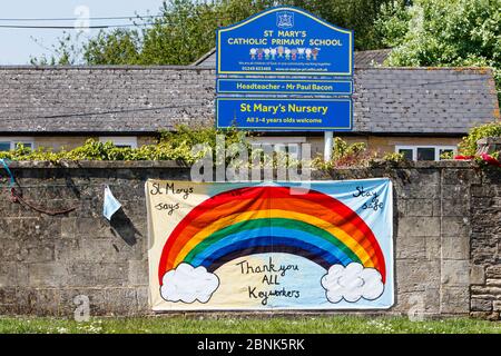 Un segno di 'grazie a tutti i lavoratori chiave' arcobaleno che è stato appeso su un muro della scuola primaria è raffigurato di fronte al Chippenham Community Hospital, Wiltshire. Foto Stock