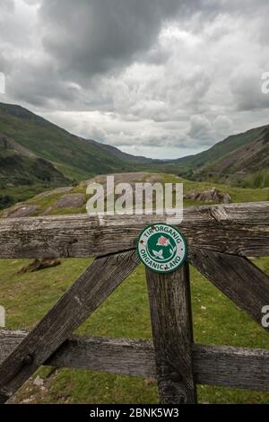 Cartello Organic Land apponed to recinto in Snowdonia National Park, Galles del nord. Luglio 2016. Foto Stock