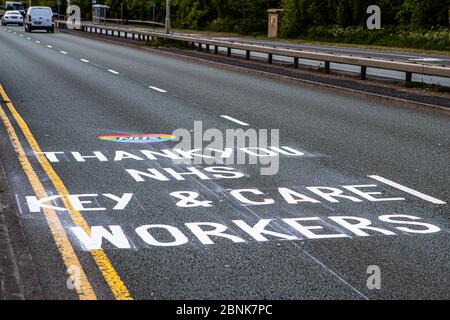 Dudley, West Midlands, Regno Unito. 15 maggio 2020. Un messaggio di apprezzamento e grazie al NHS, Key and Care Workers è dipinto sulla superficie di una trafficata strada a doppia carreggiata, durante l'avvicinamento al Russells Hall Hospital. Il messaggio dipinto è apparso durante la notte ringraziando i lavoratori durante la pandemia di Covid-19. Credit: Anthony Wallbank/Alamy Live News Foto Stock