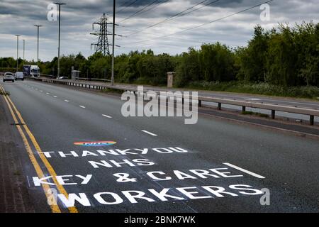 Dudley, West Midlands, Regno Unito. 15 maggio 2020. Un messaggio di apprezzamento e grazie al NHS, Key and Care Workers è dipinto sulla superficie di una trafficata strada a doppia carreggiata, durante l'avvicinamento al Russells Hall Hospital. Il messaggio dipinto è apparso durante la notte ringraziando i lavoratori durante la pandemia di Covid-19. Credit: Anthony Wallbank/Alamy Live News Foto Stock