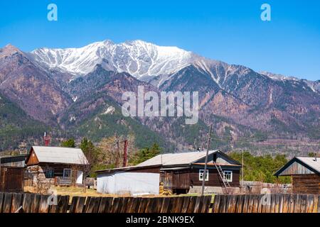 Un piccolo villaggio ai piedi delle montagne. Arshan villaggio che domina le montagne del Sayan orientale di Buryatia. Giorno di sole chiaro e cielo blu. Foto Stock