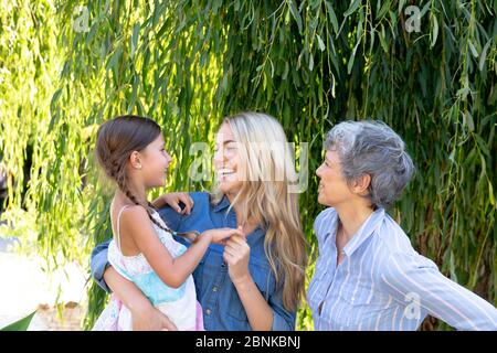 Donna caucasica anziana che passa il tempo con sua figlia e sua nipote in giardino Foto Stock