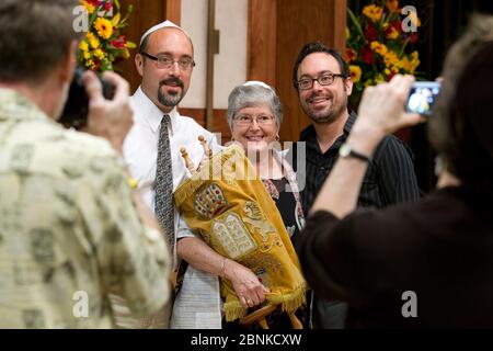 Austin, Texas USA, ottobre 26 2012: Donna ebrea, 67 anni, si pone con i suoi figli adulti mentre tiene la Torah dopo la cerimonia di Bat Mitzvah. ©Bob Daemmrich Foto Stock