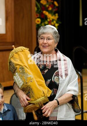 Austin, Texas USA, ottobre 26 2012: Donna ebrea, 67 anni, tiene la Torah durante il servizio di Sabbath nella sua sinagoga durante la cerimonia di Bat Mitzvah. ©Bob Daemmrich Foto Stock