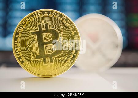 Primo piano di Bitcoin oro e argento valuta digitale in piedi sul tavolo con il computer in background. Foto Stock