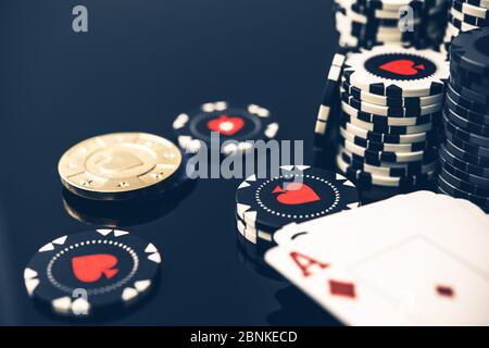 Primo piano di Bundle di chip di casinò bianco e nero carte da gioco con Ace on Top e Golden Poker chip. Foto Stock