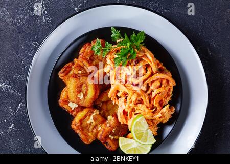 Due padelle fritte caraibiche finger food servito con pollo sminuzzato con ketchup e salsa maionese su un piatto nero, vista dall'alto, primo piano Foto Stock