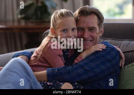 Caucasica ragazza e suo nonno passare il tempo insieme a casa seduta su un divano Foto Stock