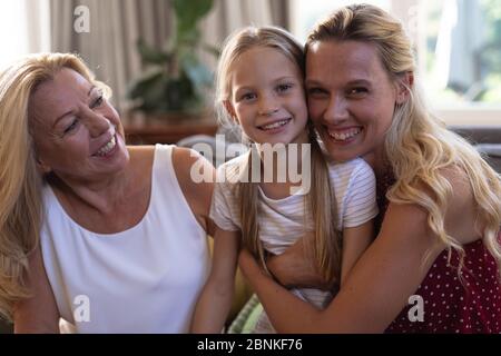 Donna caucasica con la figlia e la madre seduti su un divano Foto Stock