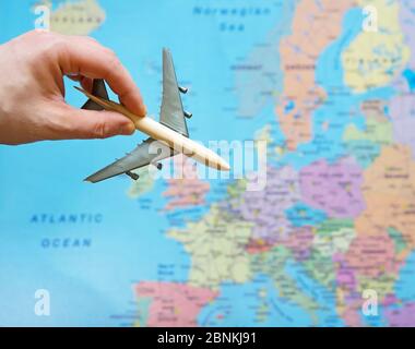 Aereo giocattolo e mappa europea sullo sfondo. Foto Stock