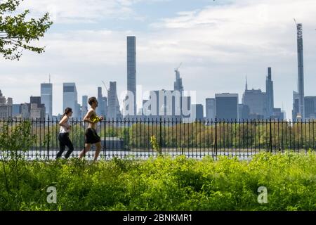 New York, Stati Uniti. 15 maggio 2020. Persone che jogging senza maschere di fronte accanto al Central Park Reservoir nella città di New York durante la crisi del coronavirus. Credit: Enrique Shore/Alamy Live News Foto Stock